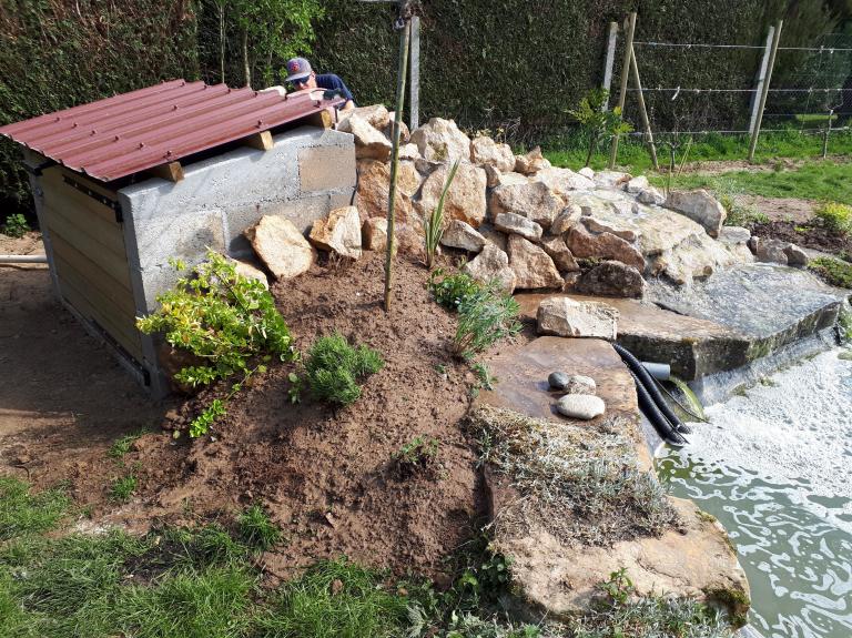 Local technique abritant filtration et pompes intégré derrière la cascade